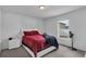 Bright bedroom with a red comforter and white nightstand at 608 Gila Dr, Kissimmee, FL 34759