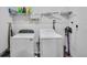 Bright laundry room with washer, dryer, and shelving at 608 Gila Dr, Kissimmee, FL 34759