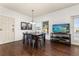 Spacious dining area with a wood table and chairs, hardwood floors, and a TV at 8984 Silver Pl, Kissimmee, FL 34747