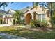 Tan one-story house with a two-car garage and green lawn at 9650 Bay Pine Ln, Orlando, FL 32832