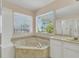 Bathroom features a corner bathtub and large window at 1020 Golf Course Pkwy, Davenport, FL 33837