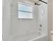 Clean bathroom with white tile and bathtub at 1020 Golf Course Pkwy, Davenport, FL 33837