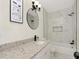 Stylish bathroom featuring marble-look tile, modern fixtures, and a granite vanity at 1234 Lynwood Ave, Apopka, FL 32703