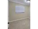 A bedroom with tile flooring, a large window, and light tan walls at 1427 Wilton Ave, Orlando, FL 32805