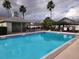 Inviting community pool surrounded by a fence, palm trees, and lush landscaping at 2528 Chatham Cir, Kissimmee, FL 34746