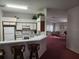 Compact kitchen with white appliances, breakfast bar, and adjacent dining/living area at 2528 Chatham Cir, Kissimmee, FL 34746
