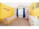 Bright yellow bedroom with a daybed, dresser, and festive holiday decor at 3896 Grassland Dr, Orlando, FL 32824