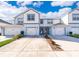 Charming two-story townhome with white siding, attached garage, and landscaped front yard at 3896 Grassland Dr, Orlando, FL 32824