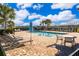 Community pool with lounge chairs, tables, and a blue umbrella on a sunny day at 3896 Grassland Dr, Orlando, FL 32824
