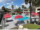 Community pool with red umbrellas and lounge chairs at 5245 W Irlo Bronson Memorial Hwy # 115, Kissimmee, FL 34746