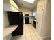 Compact kitchen featuring black appliances, white cabinetry, and tiled flooring at 6180 Hemlock Rd, Ocala, FL 34472