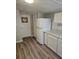 White kitchen cabinets, refrigerator, and wood-look floors at 721 Langston Ave, Haines City, FL 33844