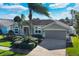 One-story home with palm trees, landscaping, and a two-car garage at 8614 Cavendish Dr, Kissimmee, FL 34747