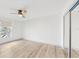 Spacious bedroom with wood-look flooring, ceiling fan, and large window at 1006 Plantation Dr # F12, Kissimmee, FL 34741