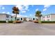 Community entrance and parking lot with tropical palm trees and landscaping at 1006 Plantation Dr # F12, Kissimmee, FL 34741