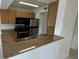 Kitchen with wood cabinets, black appliances, and granite countertops at 11562 Westwood Blvd # 914, Orlando, FL 32821