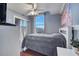 Cozy bedroom with a ceiling fan, large window, and gray bedding at 2430 Berkshire Ct, Kissimmee, FL 34746