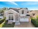 Two-story house with solar panels, a large front yard, a two-car garage, and a brick driveway at 2430 Berkshire Ct, Kissimmee, FL 34746