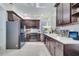 Modern kitchen with dark brown cabinets, white countertops, and stainless steel appliances at 2430 Berkshire Ct, Kissimmee, FL 34746