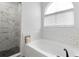 Bright bathroom with subway tile, marble shower, and soaking tub at 325 Greenwich Ct, Kissimmee, FL 34758