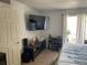 Well-lit bedroom with a mounted TV, work desk, and comfortable bed at 508 Orange Dr # 20, Altamonte Springs, FL 32701