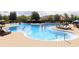 Community pool with lounge chairs, umbrellas, and people swimming at 5414 Catmint Dr, Lake Hamilton, FL 33851