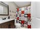 Bathroom with wood-look vanity, holiday-themed shower curtain, and Marvel character decorations at 622 Parakeet Ct, Kissimmee, FL 34759