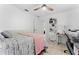 Bedroom with light pink decor, small home office area with a small white desk, printer, and chair, and a door at 622 Parakeet Ct, Kissimmee, FL 34759