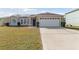 Front exterior of a single-story home with a two-car garage and solar panels at 622 Parakeet Ct, Kissimmee, FL 34759