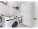 Laundry room with Samsung washer and dryer, wire shelf, and white door at 622 Parakeet Ct, Kissimmee, FL 34759