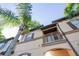 Townhome exterior with balcony, palm trees, and blue sky at 733 Calabria Ave, Davenport, FL 33897