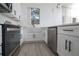 View of the kitchen highlighting the white cabinets, stainless steel appliances, and farmhouse sink at 733 Calabria Ave, Davenport, FL 33897