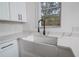Kitchen sink area with white farmhouse sink, black faucet, and quartz countertops at 733 Calabria Ave, Davenport, FL 33897