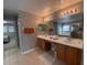 Double vanity bathroom with a large mirror and access to other rooms at 842 Sussex Dr, Davenport, FL 33896