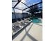 Inviting pool area with screened enclosure, lounge chairs, and spa at 842 Sussex Dr, Davenport, FL 33896