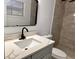 Updated bathroom with gray tile shower, gray vanity with marble countertop, and marble-look floor at 933 Windsor St, Lakeland, FL 33803