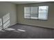 Empty bedroom with blinds on a large window and gray carpeting at 1396 Peaceful Nature Way # 1396, Clermont, FL 34714