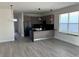Modern kitchen with dark cabinets, black appliances, and an island with black countertop at 1396 Peaceful Nature Way # 1396, Clermont, FL 34714