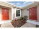 Inviting entryway with red doors, landscaping, and walkway at 1844 Ancestry Trl, Kissimmee, FL 34746