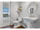 Stylish powder room with a pedestal sink, and wood flooring at 3167 Whisper Wind Dr, St Cloud, FL 34771