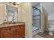 Modern bathroom with granite countertops, wood cabinetry, and tiled shower at 3305 Cat Brier Trl, Harmony, FL 34773
