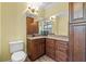 Bathroom with dark wood vanity, corner sink, and toilet at 3305 Cat Brier Trl, Harmony, FL 34773