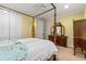 Bedroom with four-poster bed, wooden dresser, and ensuite bathroom access at 3305 Cat Brier Trl, Harmony, FL 34773