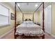 Bedroom with four-poster bed, white bedding, and carpeted floors at 3305 Cat Brier Trl, Harmony, FL 34773