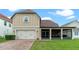 Exterior view of a home with a two-car garage, screened porch, and landscaped backyard at 3305 Cat Brier Trl, Harmony, FL 34773