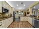 White kitchen cabinets, granite countertops, stainless steel appliances, and an island at 3305 Cat Brier Trl, Harmony, FL 34773