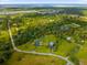 Aerial view showcasing a house, detached garage, and lush green landscape at 5155 Haywood Ruffin Rd, Saint Cloud, FL 34771