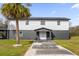 Modern two-story house with gray and white exterior, palm tree, and walkway at 5155 Haywood Ruffin Rd, Saint Cloud, FL 34771