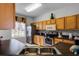 Kitchen with light wood cabinets, black countertops, and stainless steel appliances at 673 Copeland Dr, Haines City, FL 33844