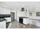 Modern kitchen with white cabinets, granite countertops, and stainless steel appliances at 723 Florida Pkwy, Kissimmee, FL 34743